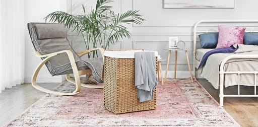 Sypialnia z łóżkiem, fotelem i koszem, stworzona w przytulnym i funkcjonalnym stylu.