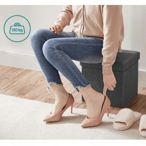 Osoba ubierająca buty która jednocześnie siedzi na szarej pufie.