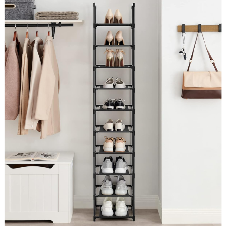 Modułowa czarna szafka z butami na każdej półce obok garderoby i wiszącej torebki po prawej stronie.