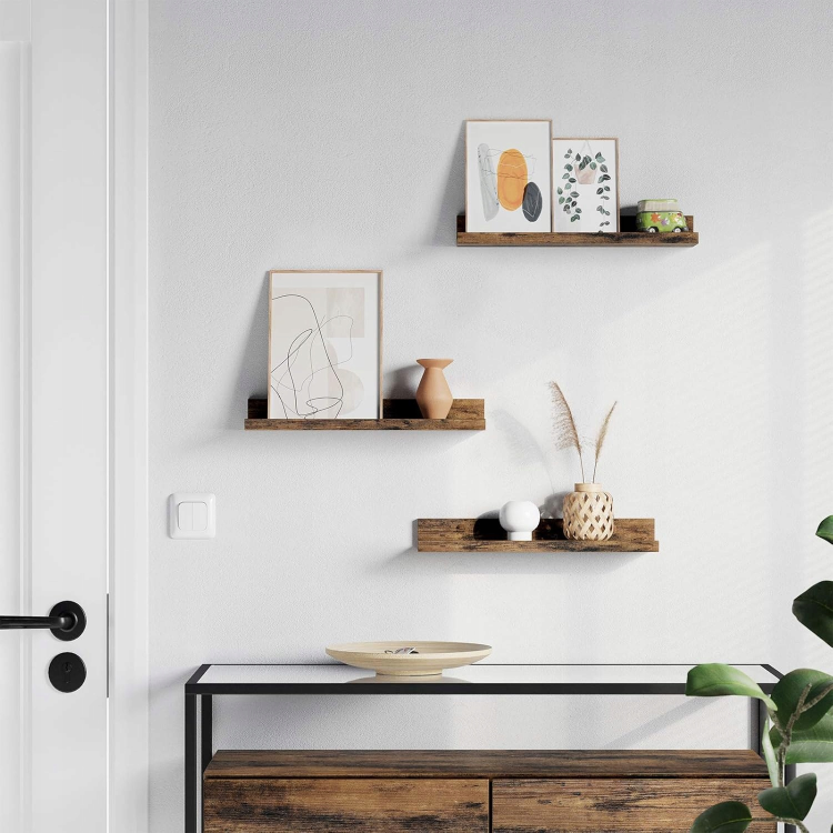 Rustykalne półki ścienne jako element dekoracyjny salonu. Ciemne drewno doskonale kontrastuje z jasnymi ścianami, dodając wnętrzu ciepła i industrialnego charakteru w stylu loft.