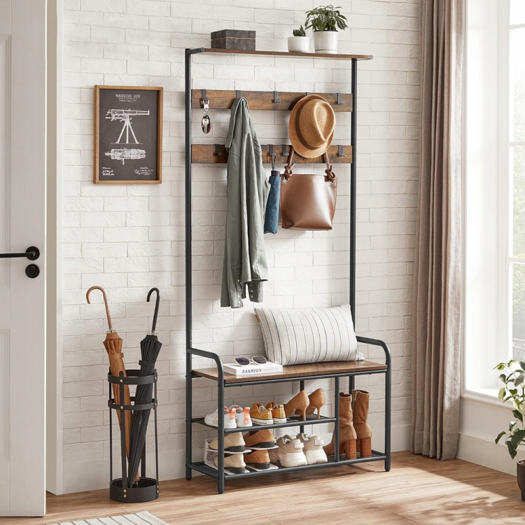 Stylowy wieszak stojący z szafką na buty. Połączenie ciemnego metalu z ciepłym kolorem drewna (rustic brown) nadaje wnętrzu industrialnego charakteru, tworząc uporządkowaną i zapraszającą strefę wejściową.