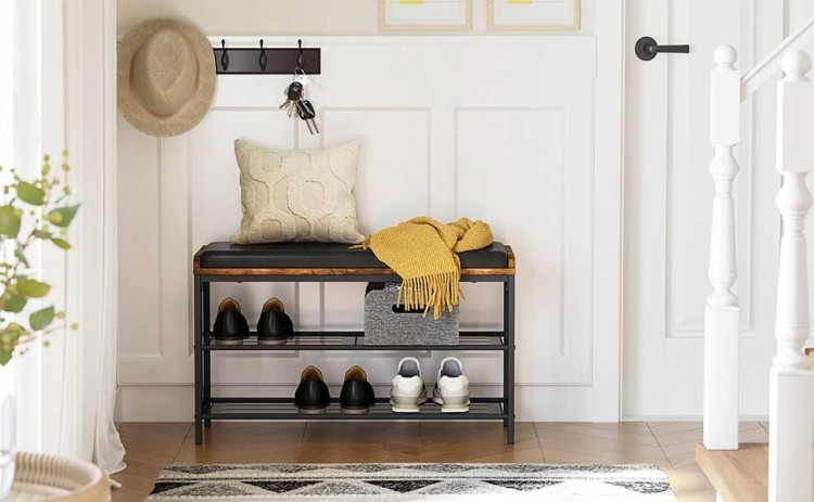 Tapicerowana szafka, uzupełniona butami z szalem i poduszką leżącą na siedzisku.