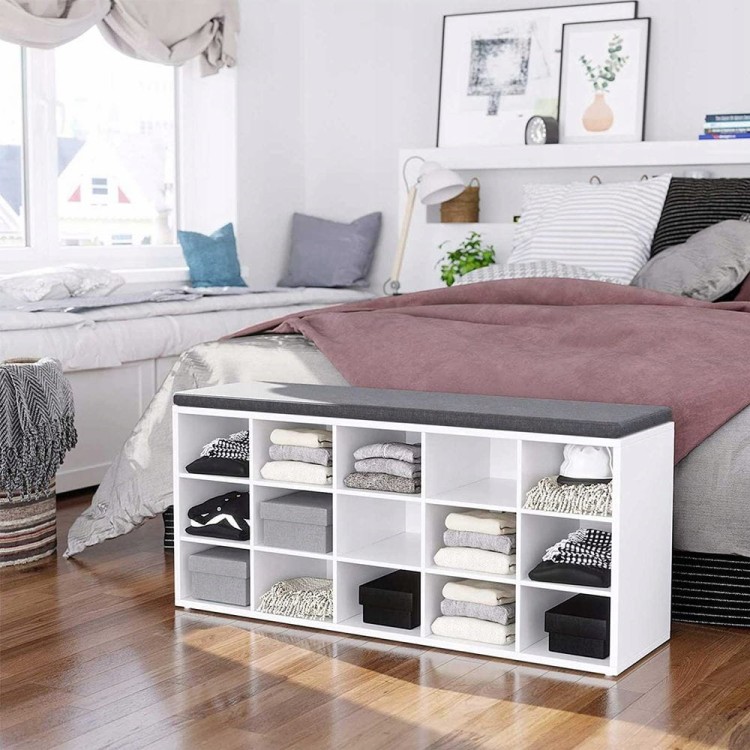 Regał z licznymi półkami, wypełniony ubraniami.